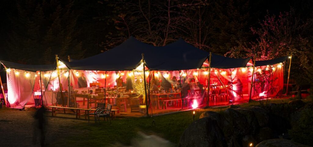 Stimmungsvolle Zeltbeleuchtung mit Lichterketten bei einem Outdoor-Event von Mo’s tent&event.