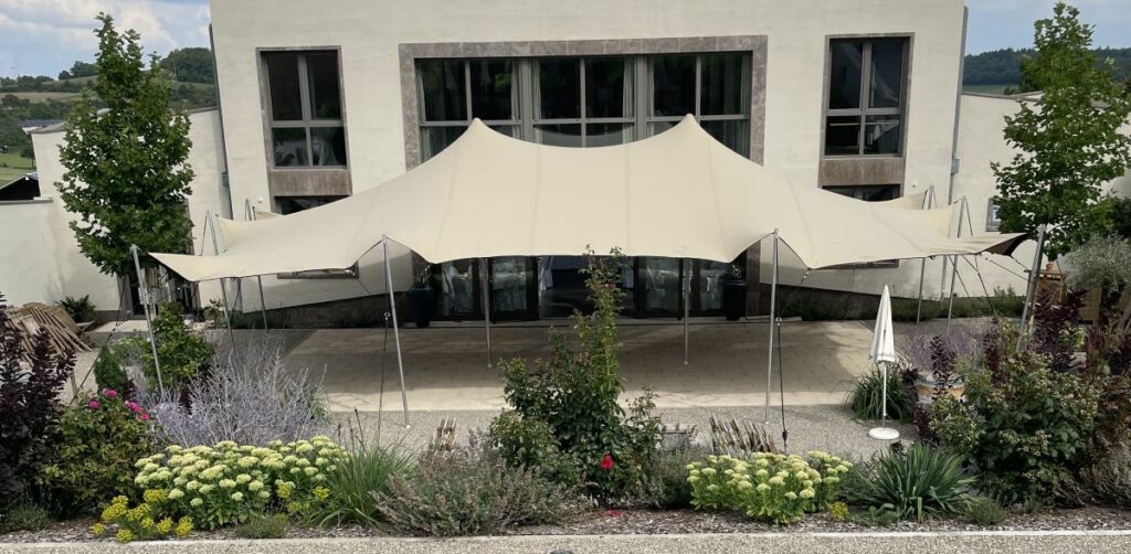 Flexzelt als Terrassenüberdachung für Gastronomie & Hotellerie, direkt an das Gebäude angebunden