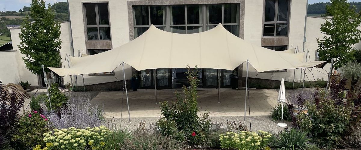Flexzelt als Terrassenüberdachung für Gastronomie & Hotellerie, direkt an das Gebäude angebunden